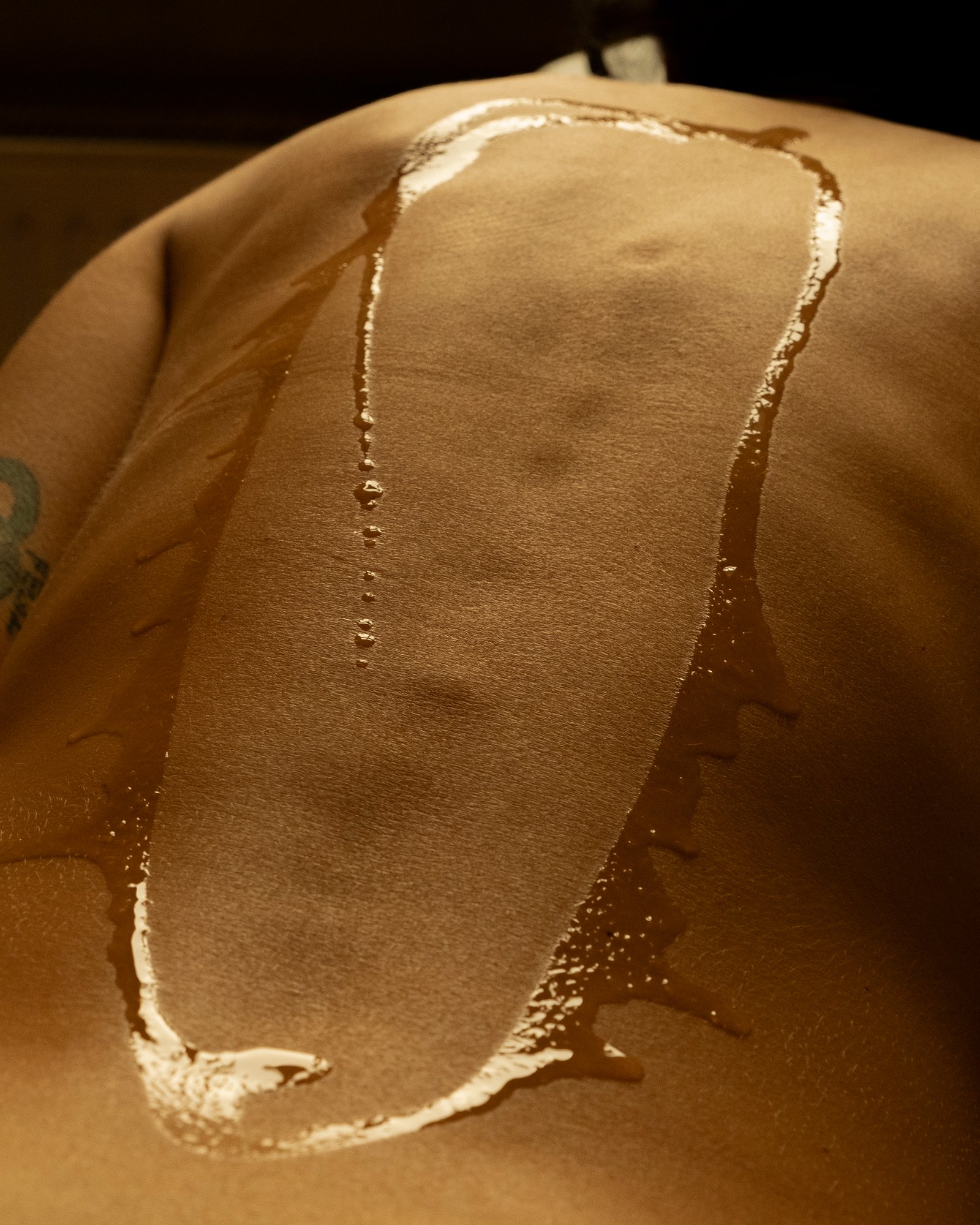 Close-up of oil application on a client's back during a somatic de-armoring session in Berlin for tension and chronic pain relief